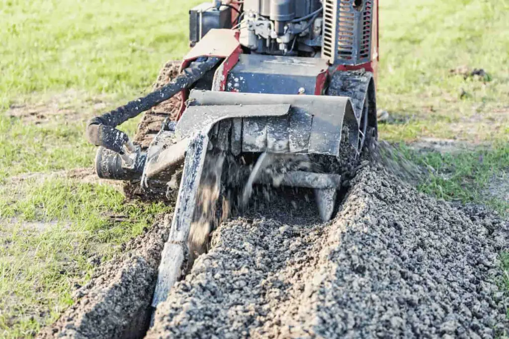 Large trencher cutting a groove into the lawn