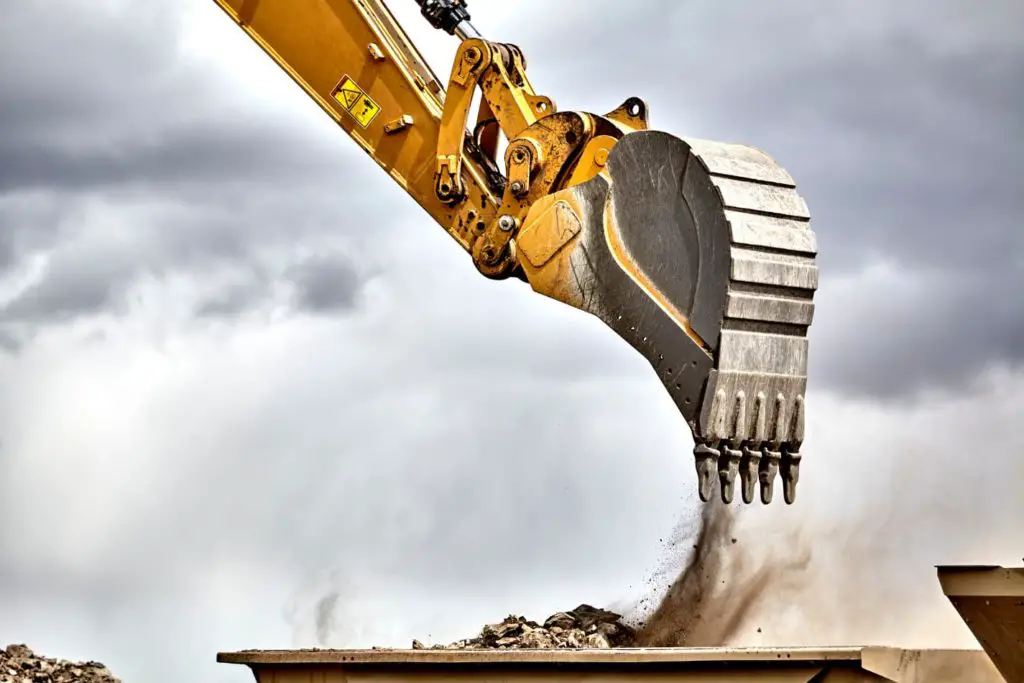 Dump truck being filled with dirt from an excavator